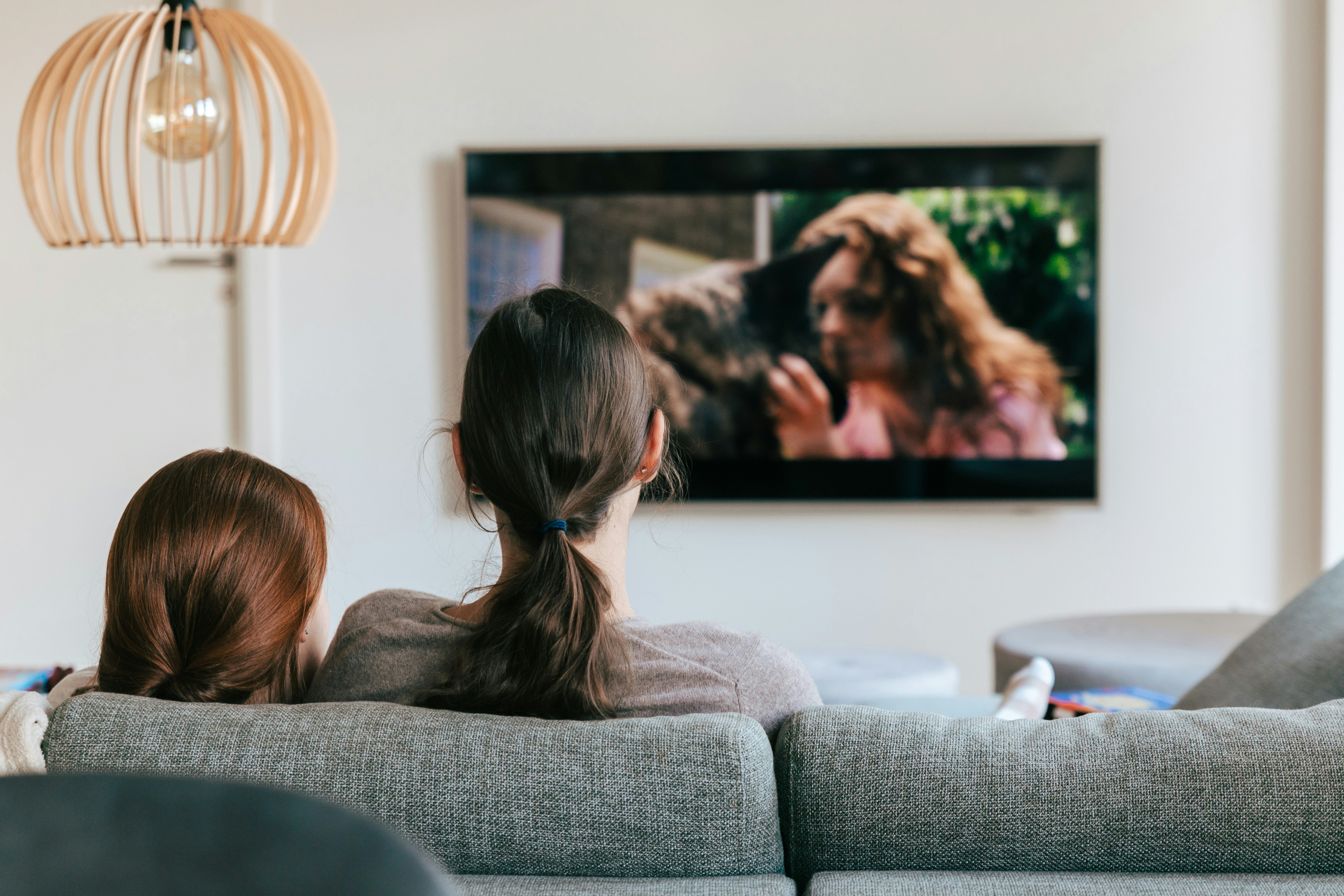 A mom and daughter watching TV together.