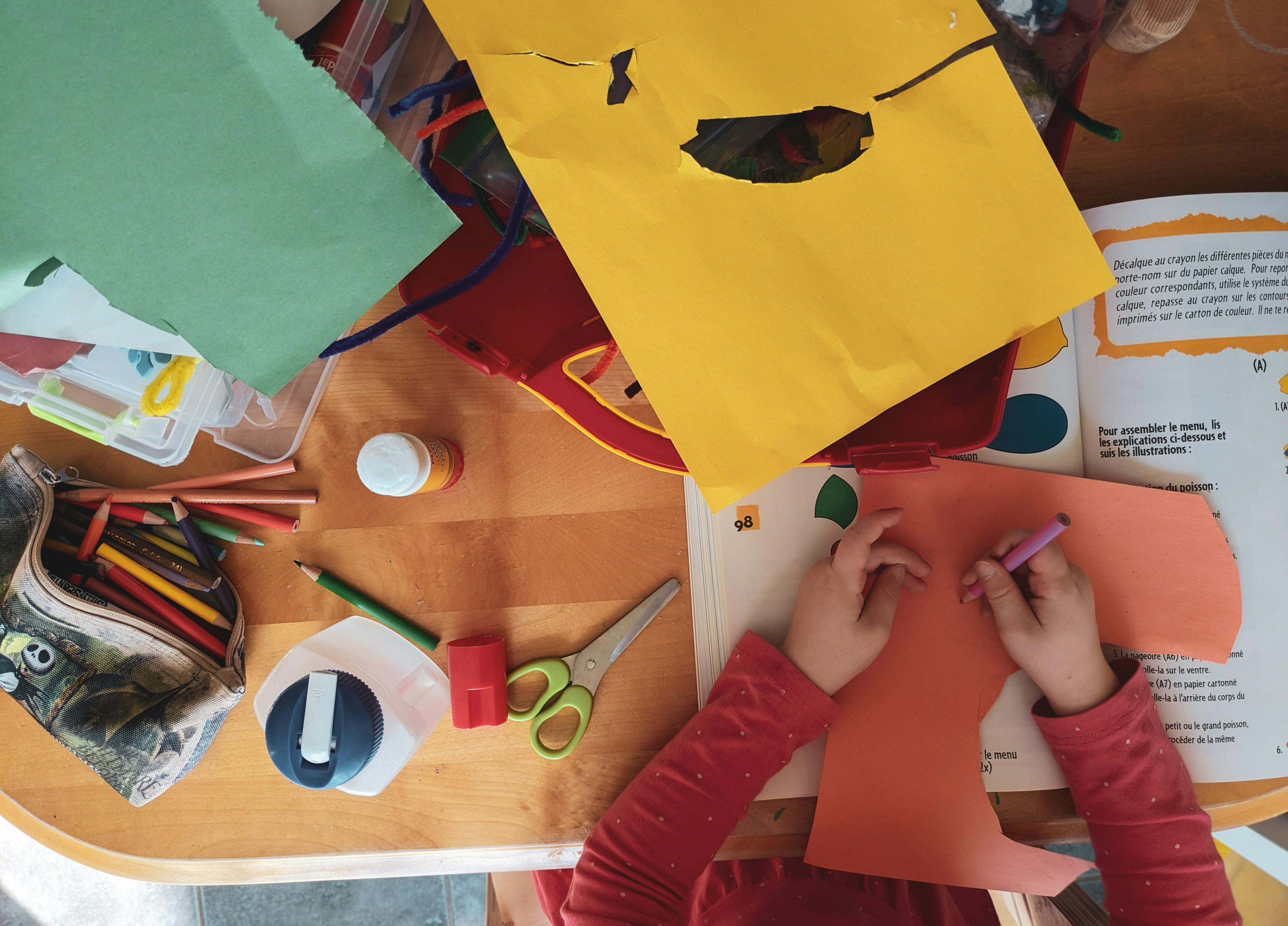 A child at a table full of crafts.